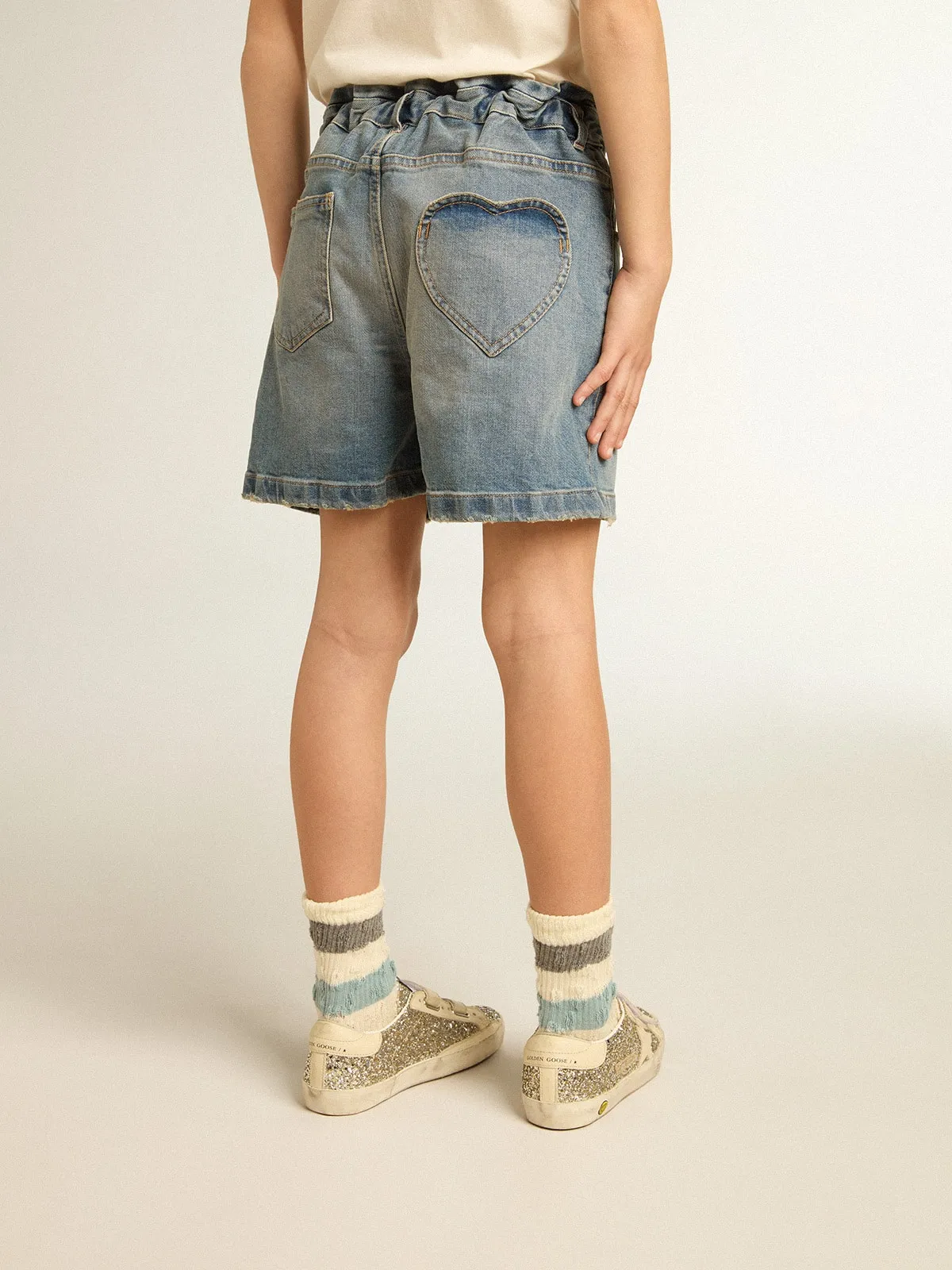 Pantalón corto en tejido vaquero de niña de efecto desgastado